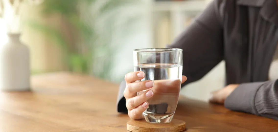 Patient holding a glass of water for hydration after weight loss surgery